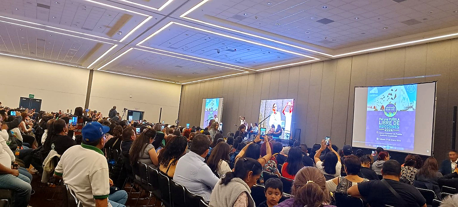 Conferencia en Puebla con público y pantallas